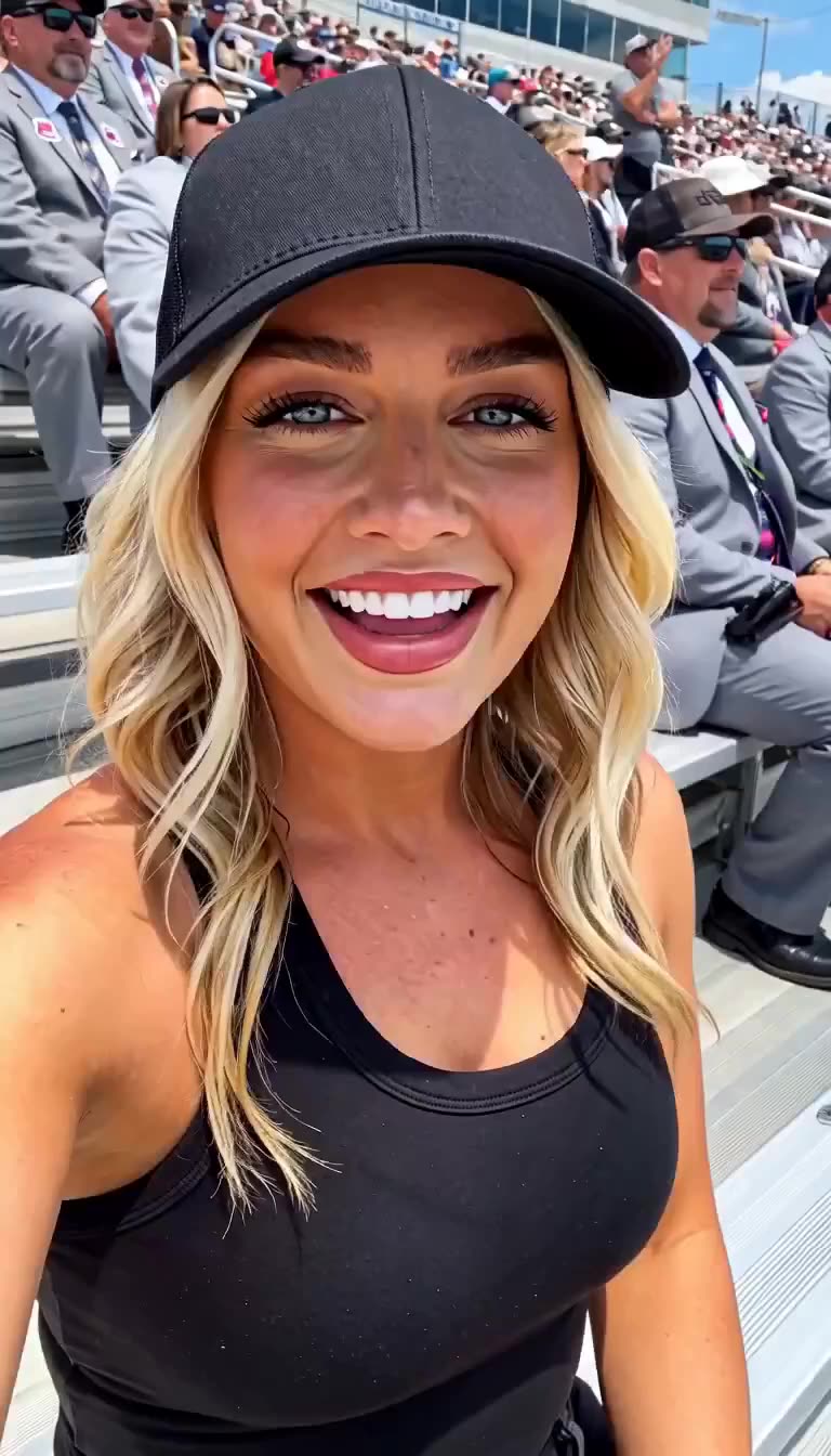 Samantha Miller laughing in the grandstands with suited race officials seated behind her