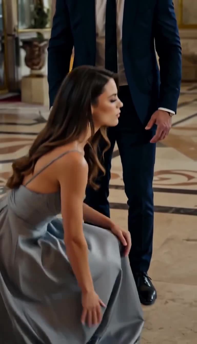 Elena begins to stand up gracefully in her evening dress as the arrogant executive freezes in disbelief.