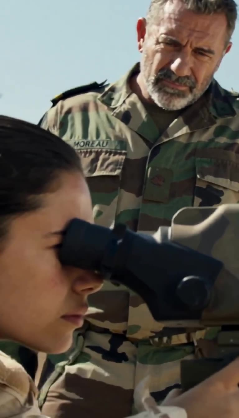 Close-up of Commander Moreau looking down skeptically at Nora during training