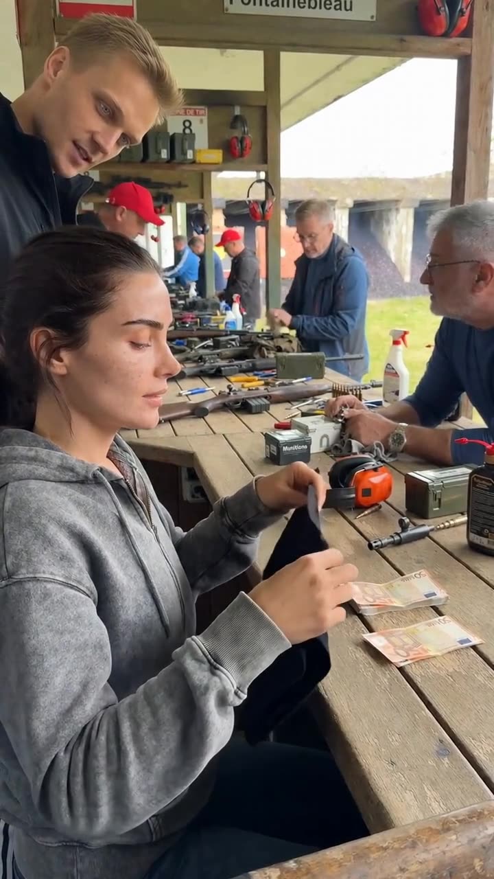 Camille pulling out a black cloth to blindfold herself beside the wagered cash on the bench.