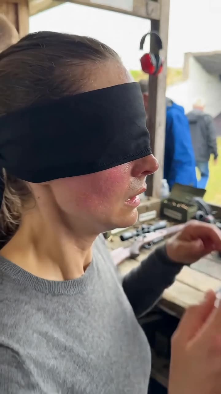 Camille wears a black blindfold while handling her rifle at the shooting club.