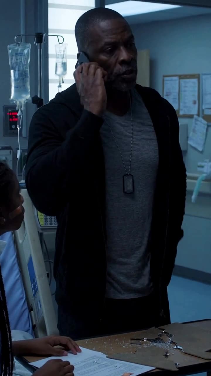 Marcus holding a phone to his ear with an unyielding gaze as he orders a complete facility lockdown.