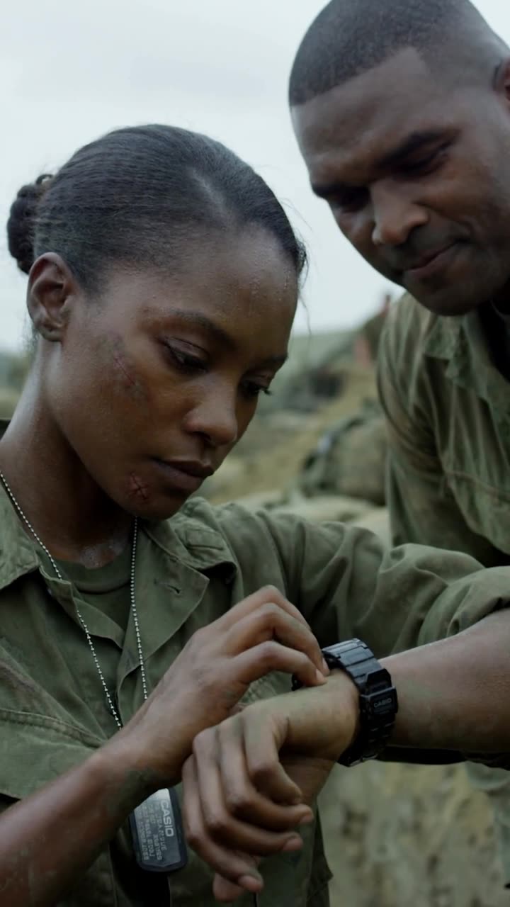 Maya turns her black digital watch to check the time with a calm, unblinking expression.