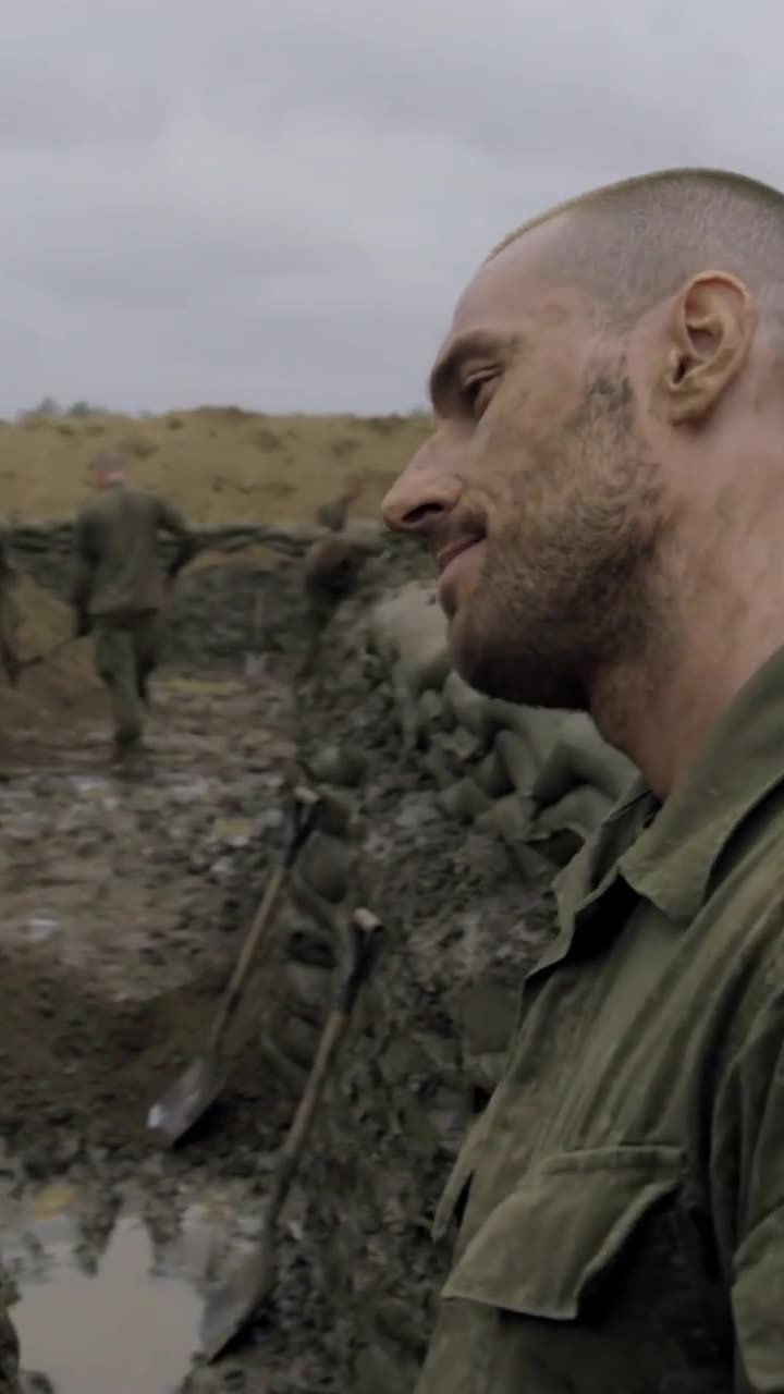 A smirk washes across the sergeant's face as recruits dig trenches in the bleak, wet training field.