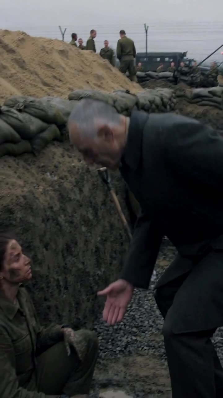 Henri crouches over the muddy ditch, offering an open hand down to Camille sitting in the trench.