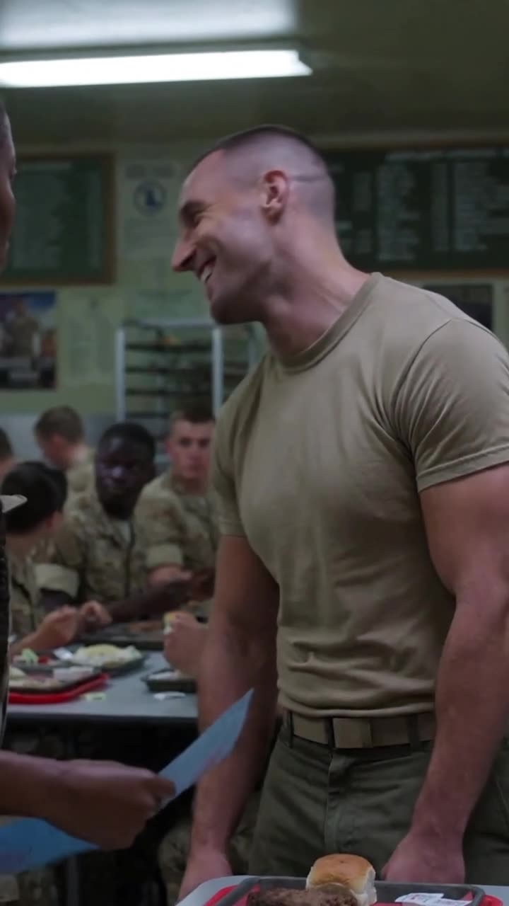 Derek laughs mockingly while recruits in uniform look on from the mess hall tables.