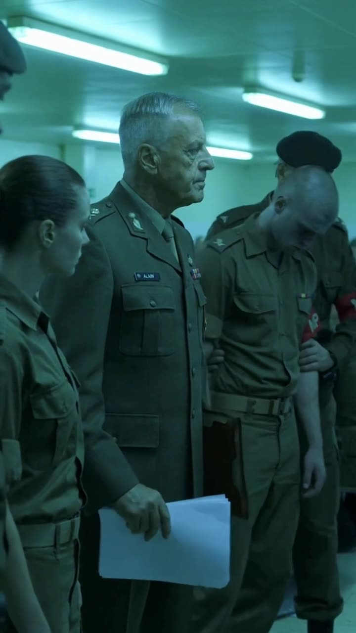 Commander Alain tucks the documents into his folder as MPs take Damien into custody.