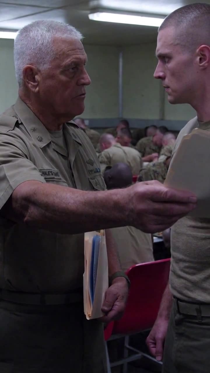Commander Robert extends the recovered forms directly toward Derek in confrontation.