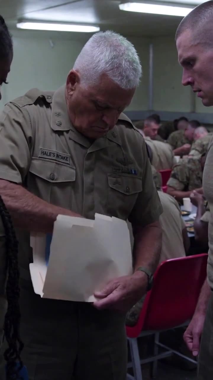 Colonel Hale reviews the stamped disciplinary paperwork inside the crowded base dining facility.