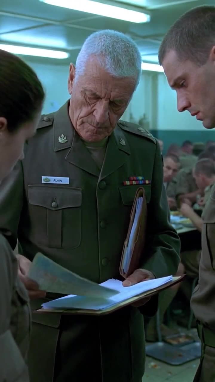 The commander and recruit examine documents together while the accused corporal looks down anxiously.
