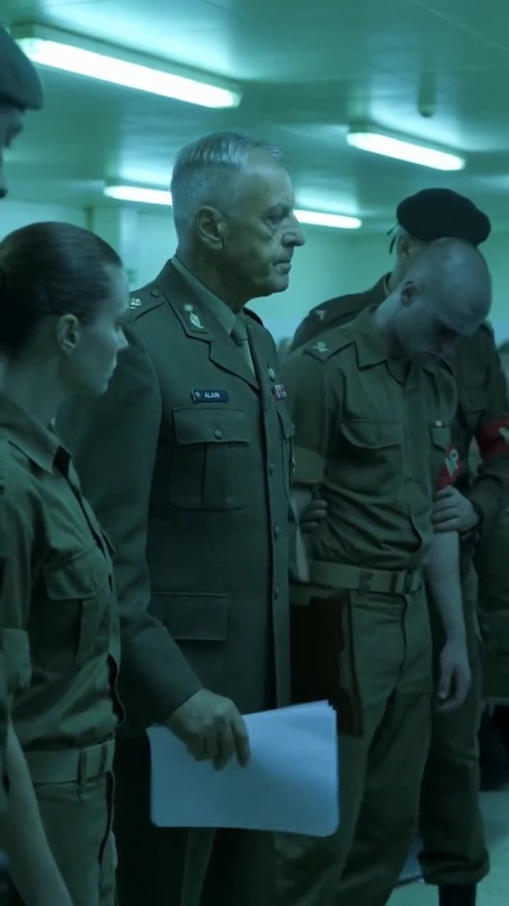 Military police escort the handcuffed corporal away with his head bowed under the watchful eyes of the commander and recruit.