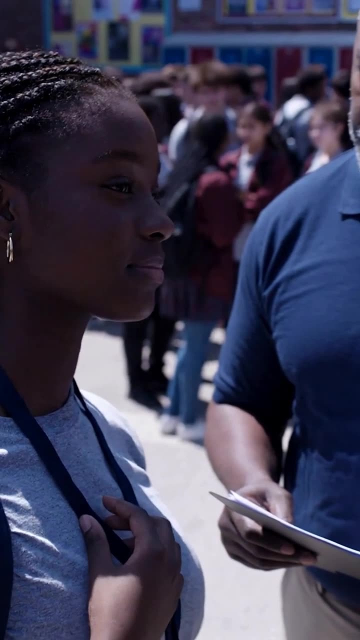 Maya stands composed with her lanyard as the truth is revealed
