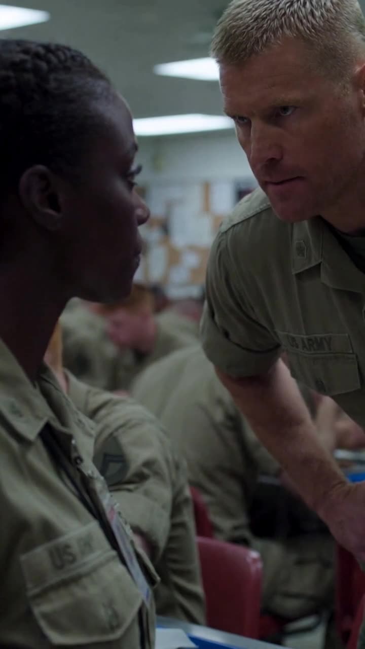 Brad leans in close to interrogate Maya as she calmly holds his gaze.
