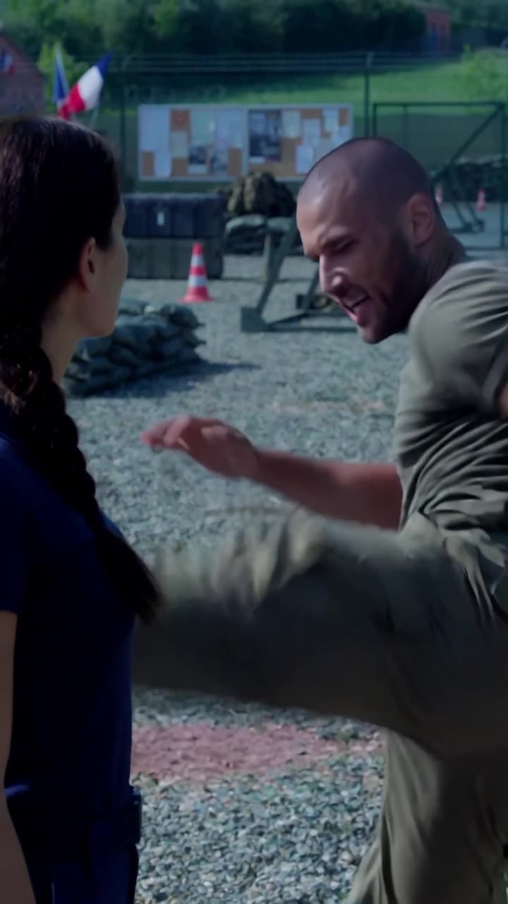 Julien executes a high martial arts kick inches away from Camille's calm, unflinching face.
