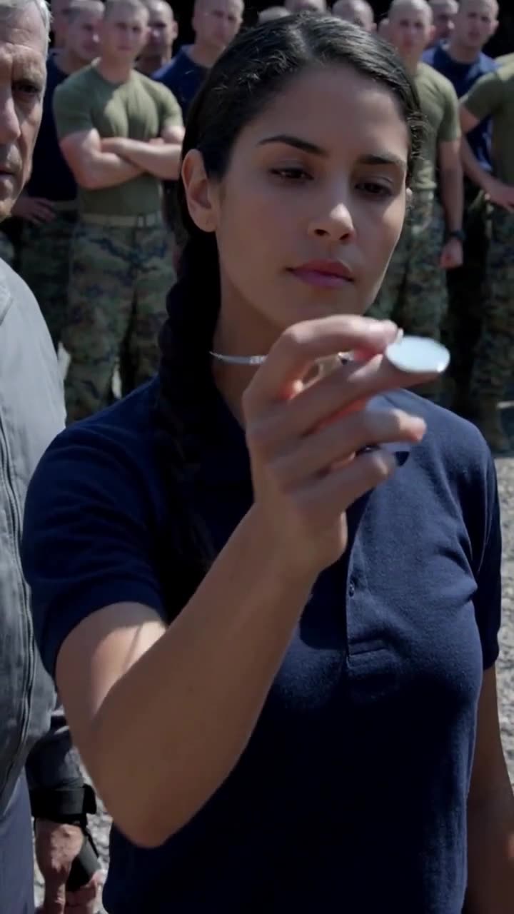 Captain Éléonore displays her elite insignia coin under the direct sunlight