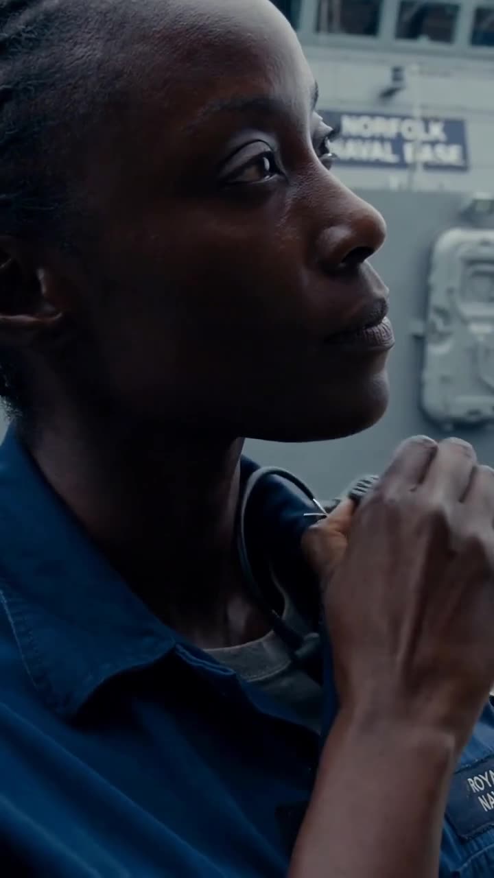 Cole discreetly activates her tactical radio mic to patch into a secure intelligence frequency.