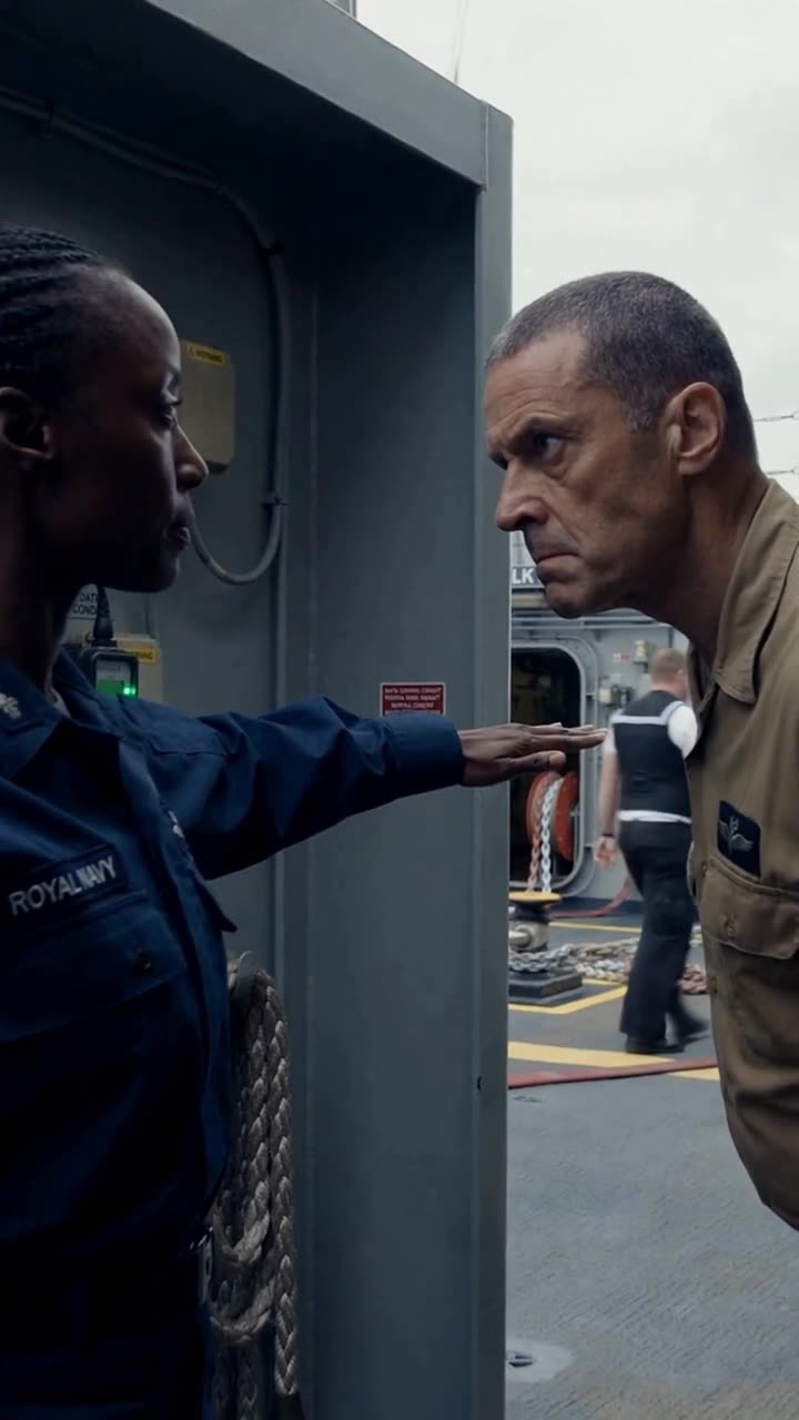 Maya raises a flat palm to block Kane as the two officers lock eyes in a tense confrontation.