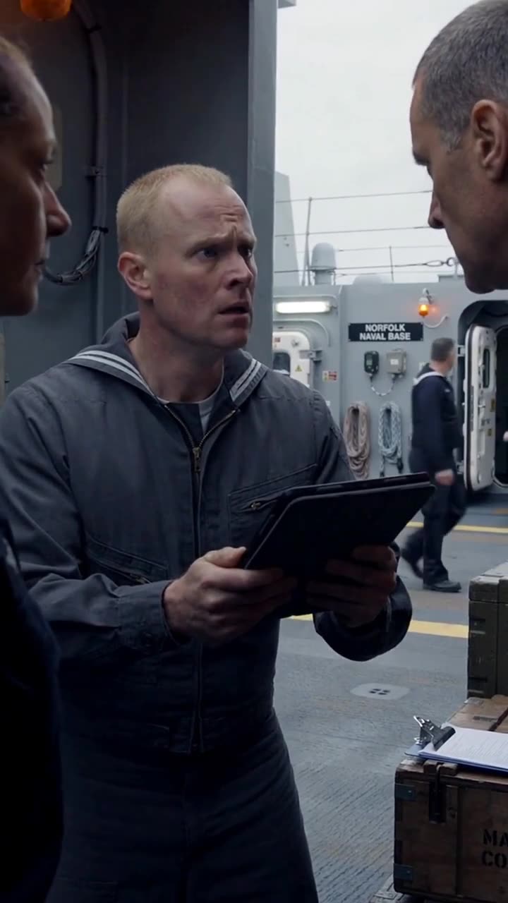 A shocked technician holds a digital tablet showing emergency alerts during the confrontation