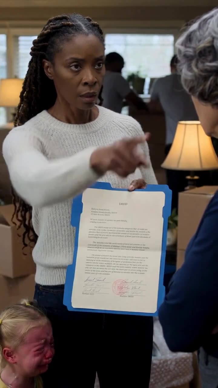 Samantha thrusts the house deed in the grandmother's face, pointing an accusing finger in defiance.