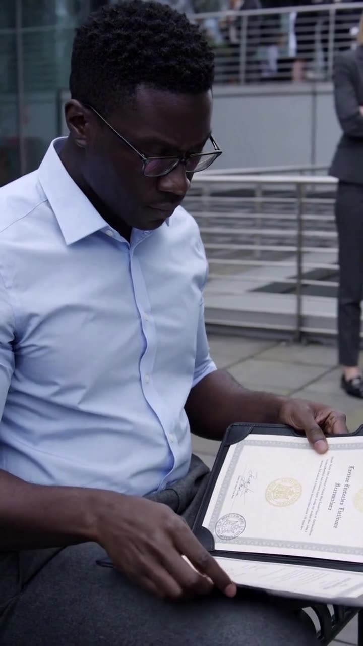 Marcus inspects the official patent certificate and embossed gold seal inside his opened leather document folder