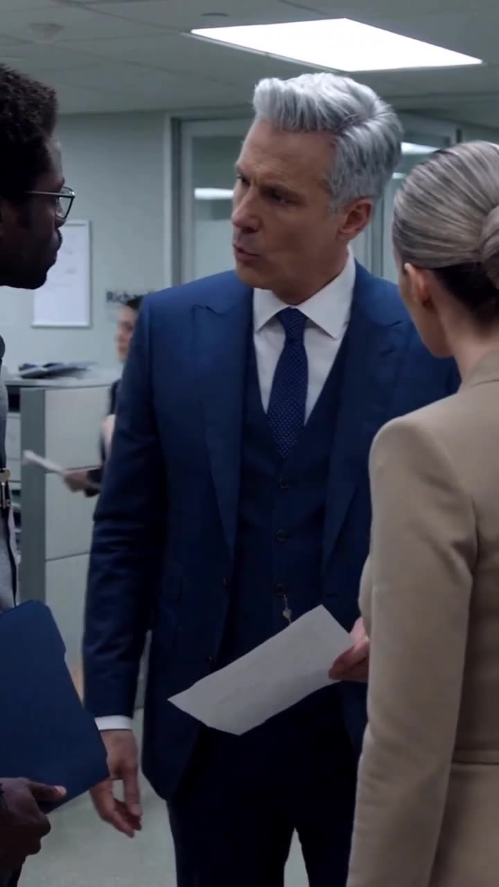 The CEO confronts the applicants with paperwork in hand, delivering his final decision.