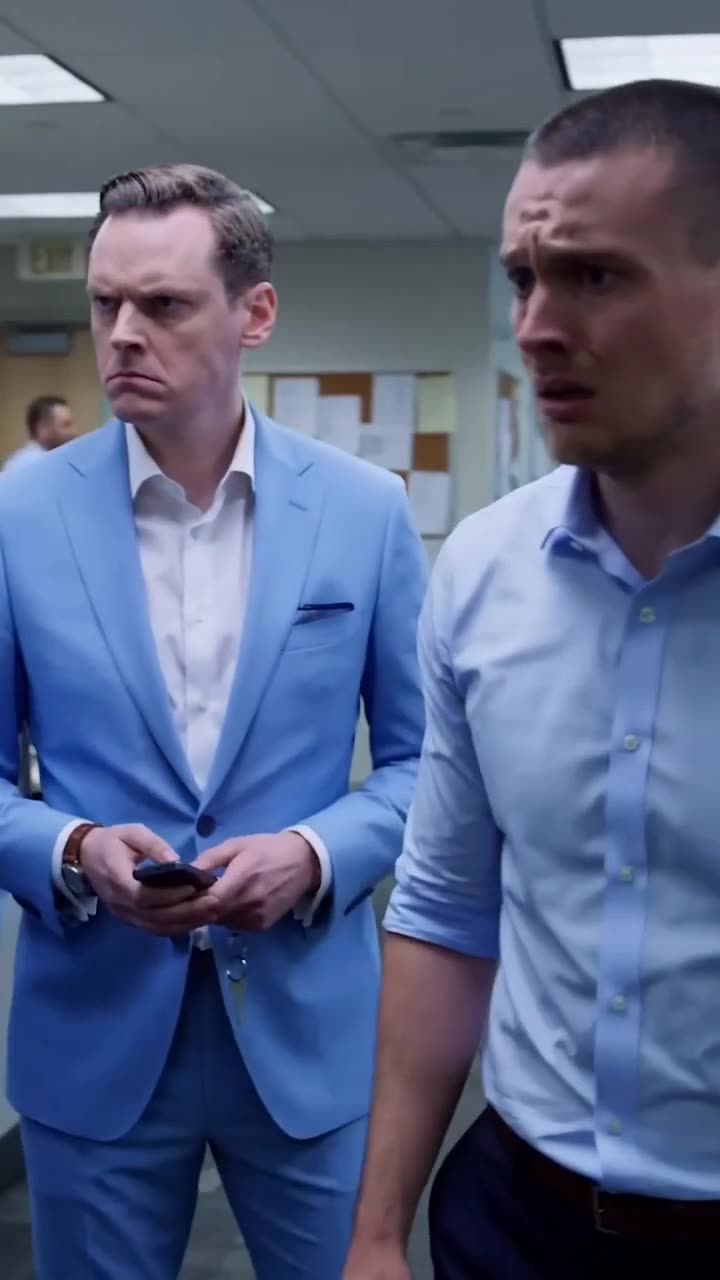 The grim-faced chief executive and the panicked staffer share a tense, silent exchange in the office corridor.
