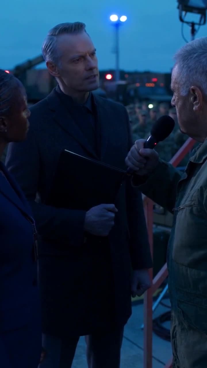 A federal investigator in a dark overcoat intervenes between Garrett and Vance