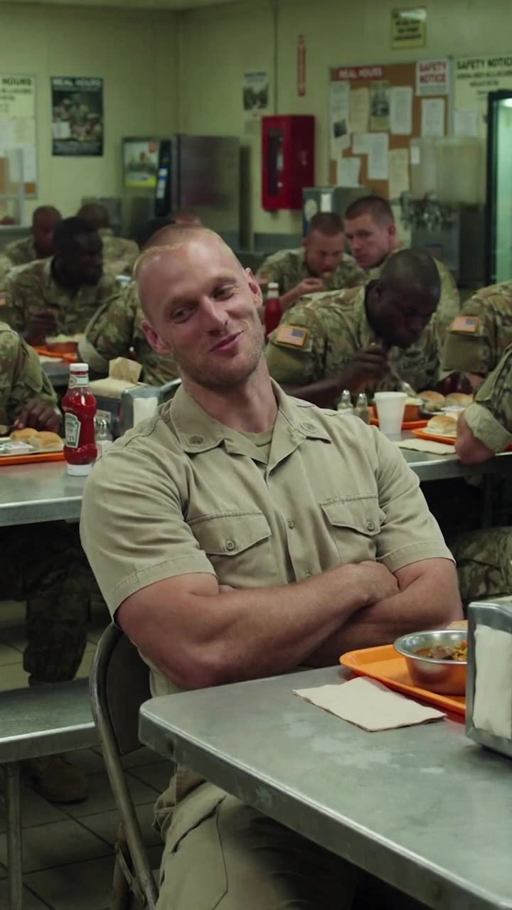 Brad chuckles dismissively at Maya while surrounded by eating soldiers.