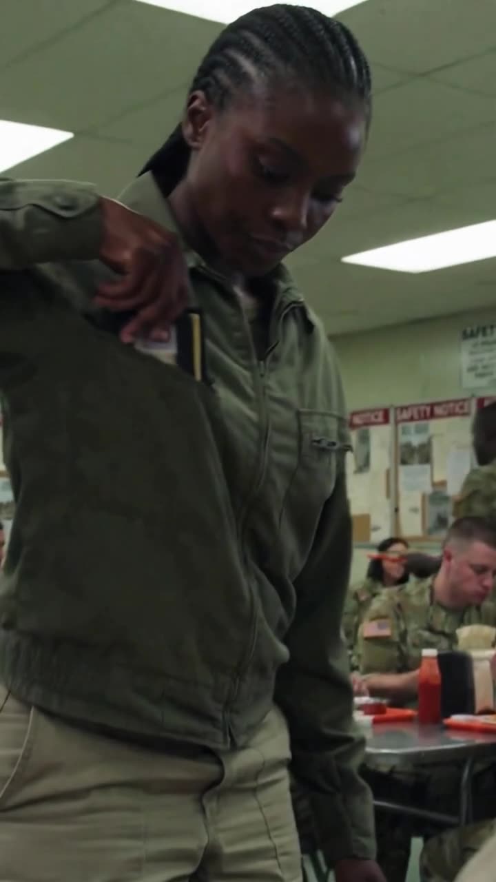 Maya reaching inside her olive uniform jacket to draw out a concealed leather cardholder