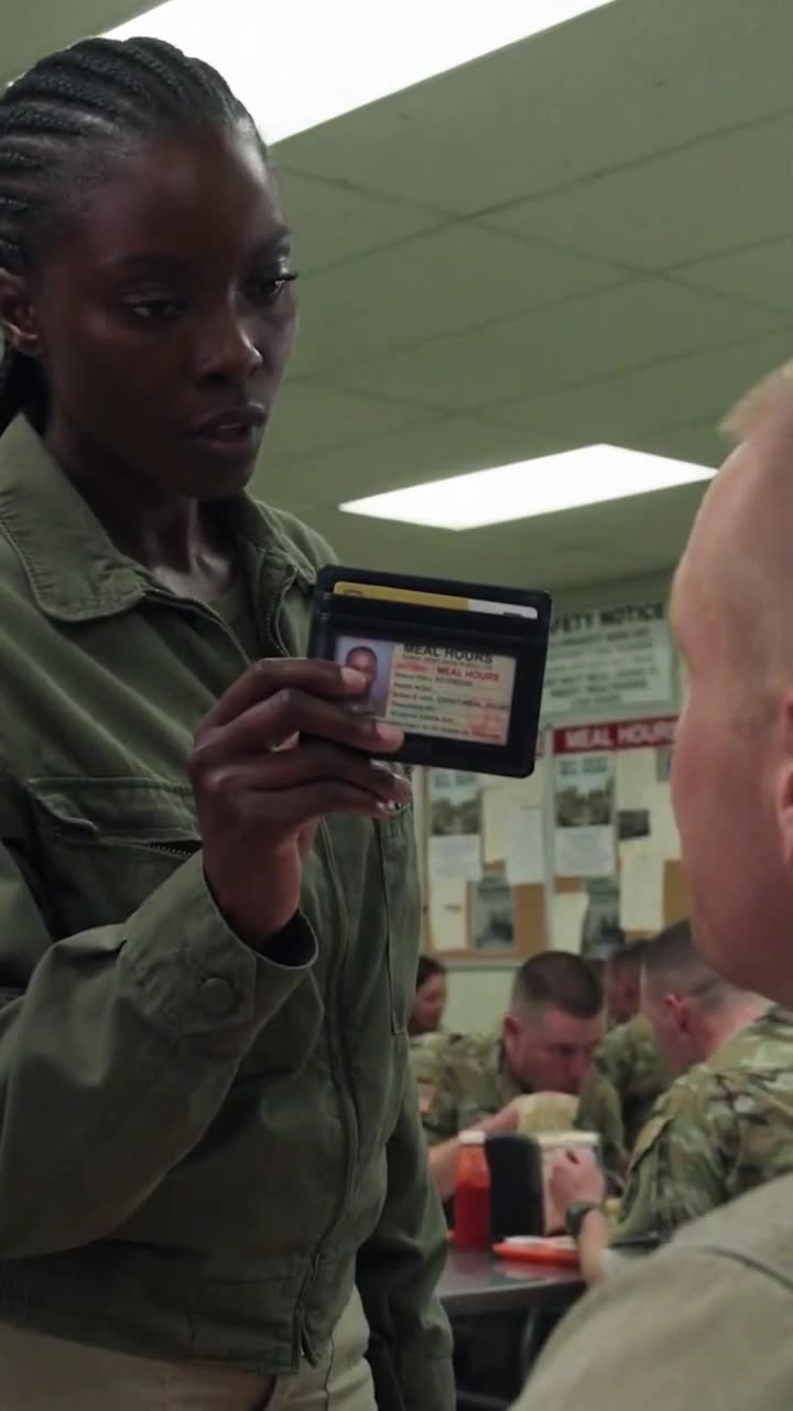 The female officer holds up her military identification card right in front of the stunned soldier's face.