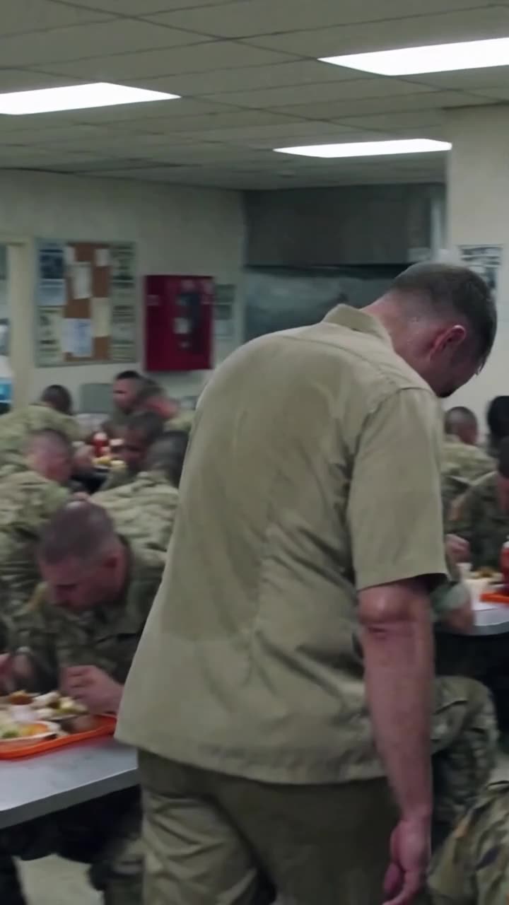 Brad lowers his head in defeat and walks away briskly through the crowded mess hall