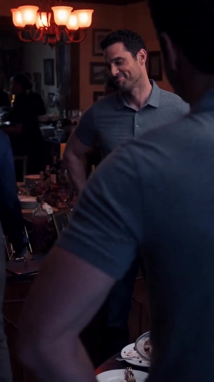 Mark smirks confidently across the dining table during the tense confrontation.