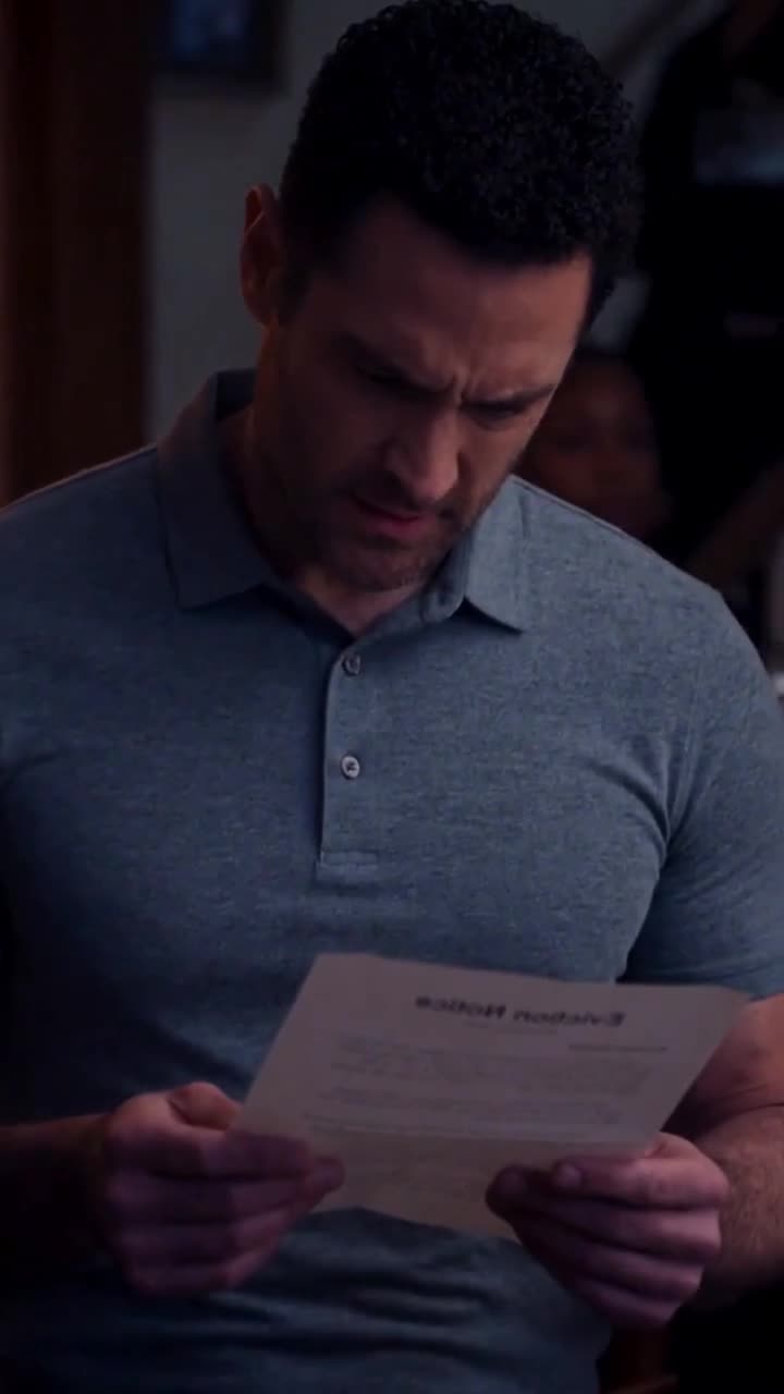 A man reacts with visible shock while reading an official eviction notice handed to him.
