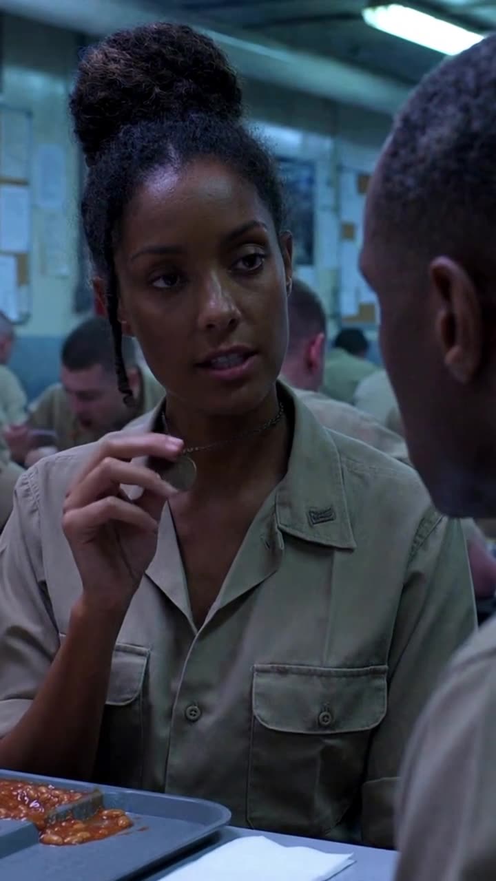Major Sarah Vance holds up a brass military auditor pendant from around her neck.