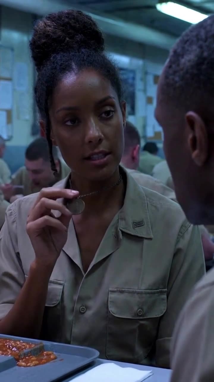 The soldier calmly holds up a medallion, meeting the sergeant's glare without fear.