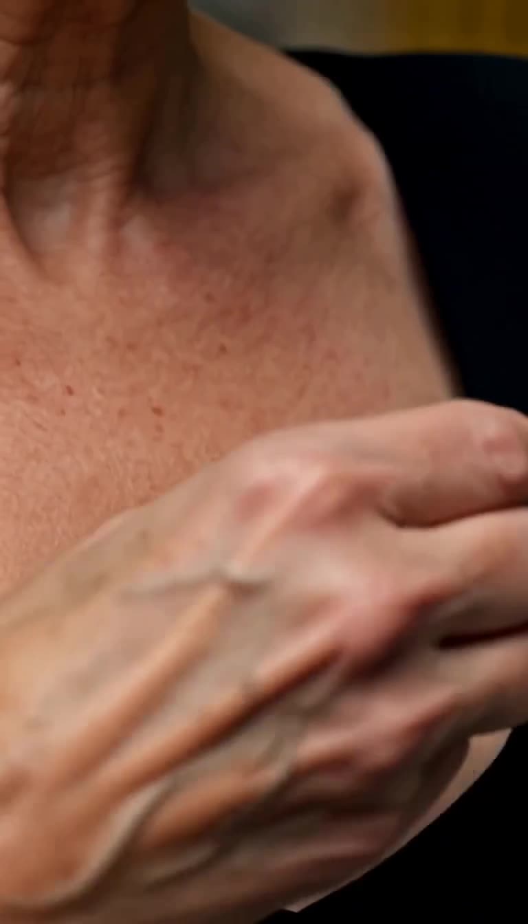 Close-up of Camille reaching into her collar to reveal a hidden signet ring
