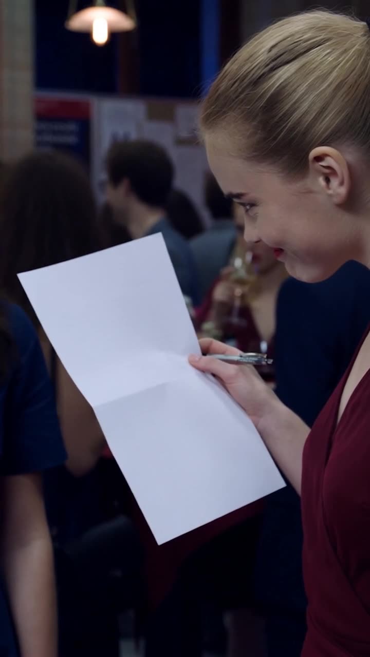 Chloé holds an official grant document to her face with a mocking sneer