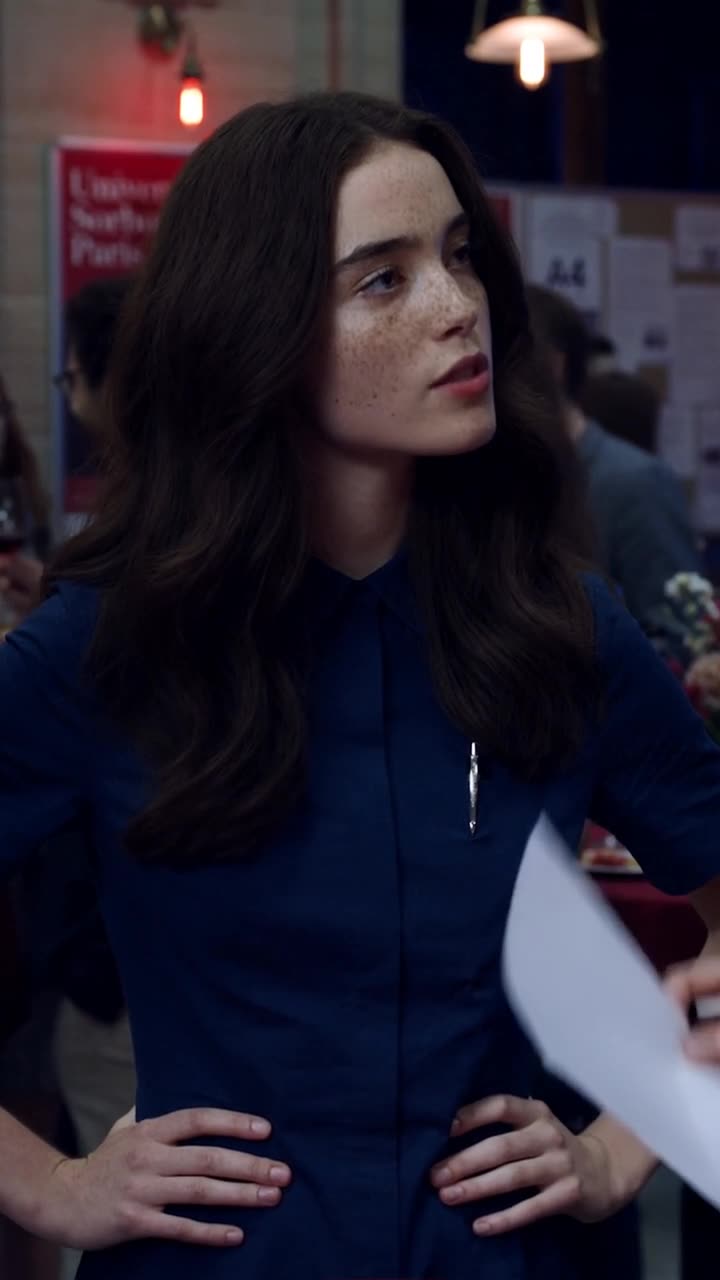 Camille places her hands on her hips and raises her chin to firmly confront Chloé