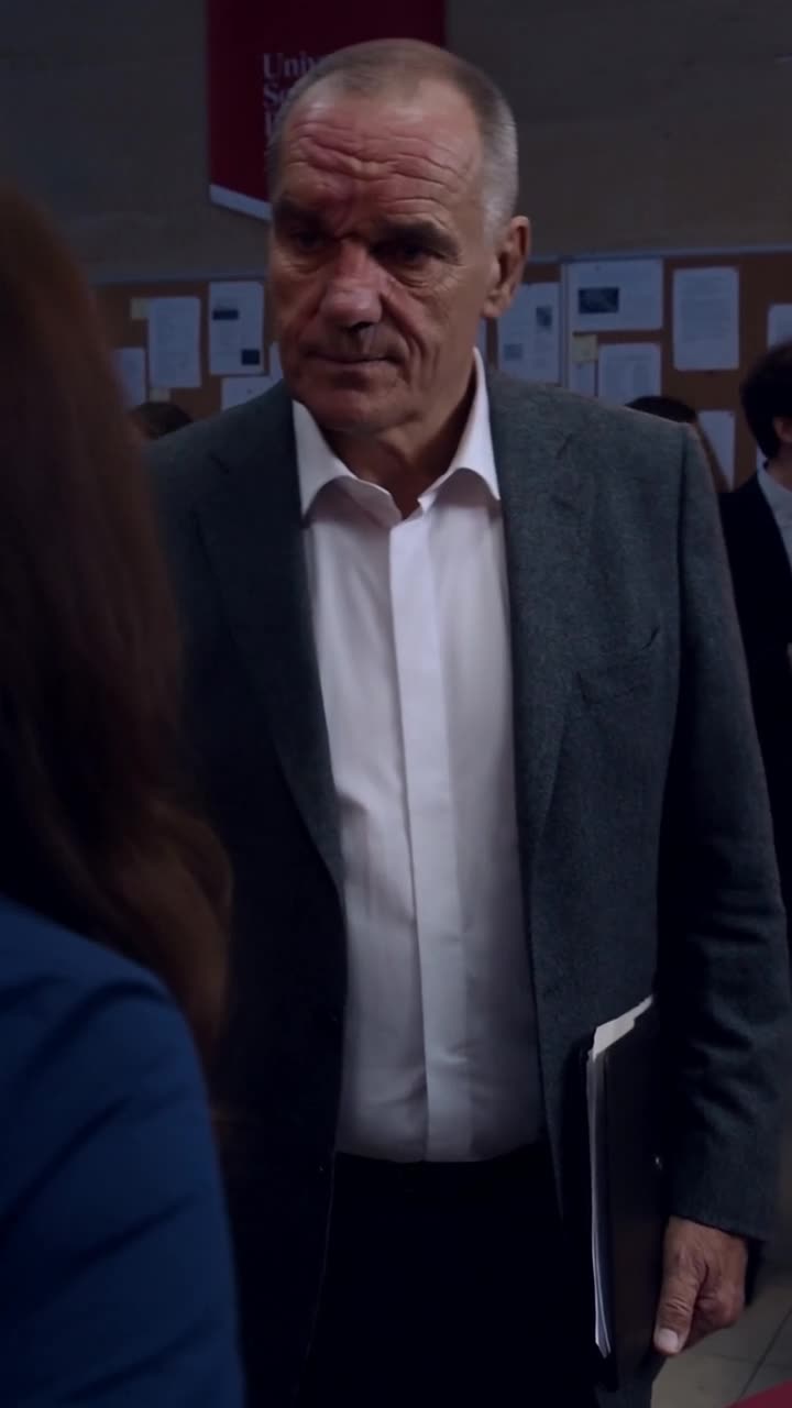 Antoine steps past Chloé with a black leather document folder to confront Camille directly.