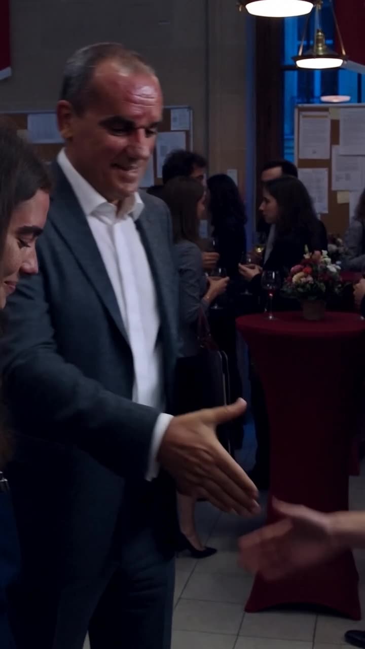 Antoine reaches out his hand to offer a formal handshake during the evening reception
