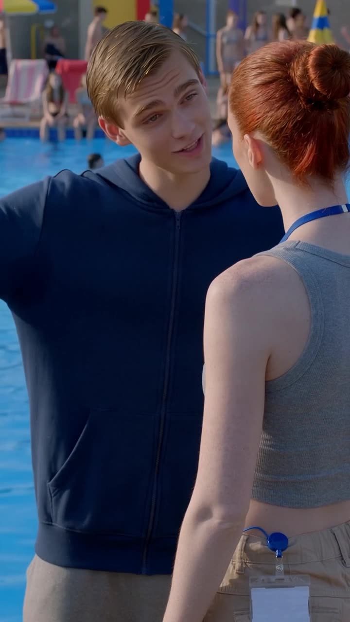 Lucas smirks arrogantly while confronting Camille at the water's edge.