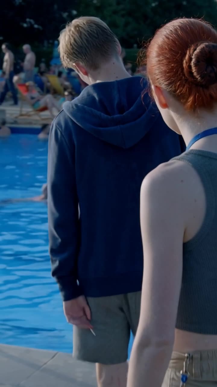 Lucas turns away and retreats toward the exit gates in defeat as Camille watches him go.