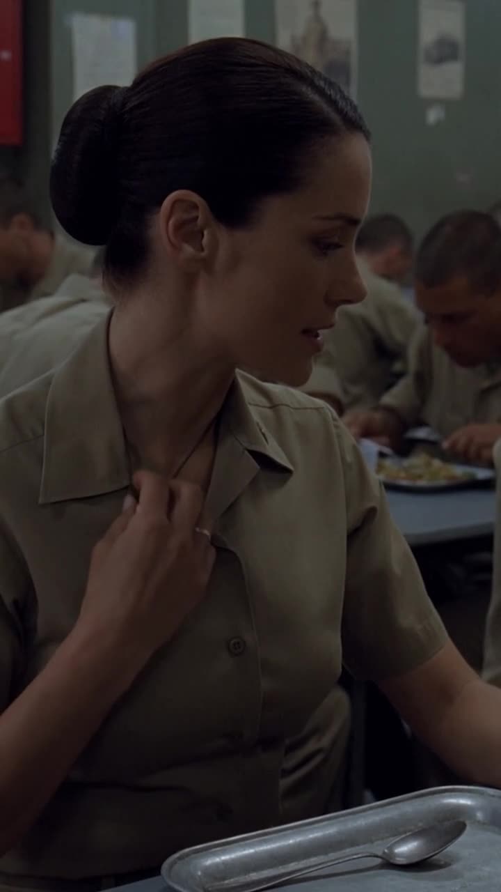 Claire reaches beneath her open collar to reveal a silver ring concealed on a cord.