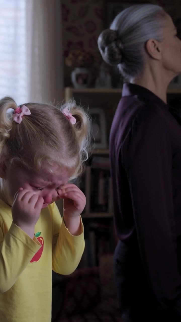 Léa cries bitterly while Monique turns her back in cold indifference.