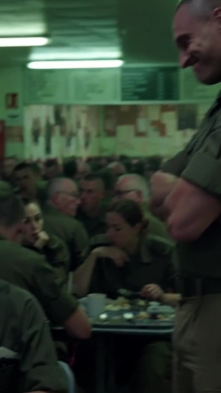 Sergeant Mercier smirks with arms crossed, mocking Élodie in front of crowded troops.