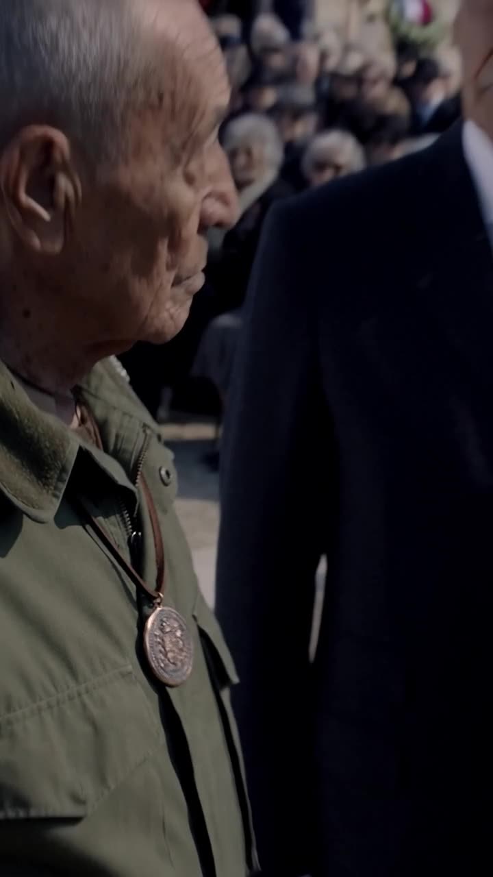 The bronze seal pendant rests squarely against Henri's olive jacket under direct sunlight.