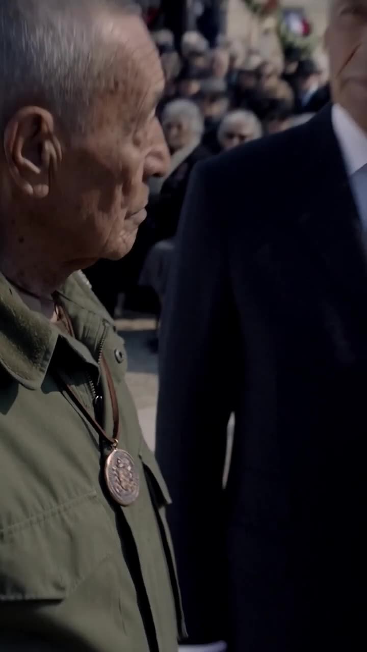 Close-up of the elderly veteran in military fatigues clutching his bronze medal with quiet dignity