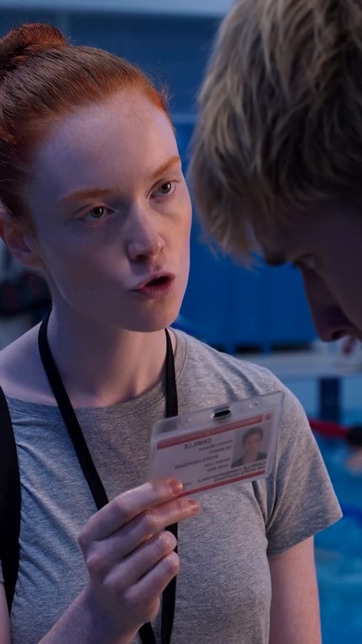 Camille glares sternly at Maxime with her official badge held high, delivering the final verdict.