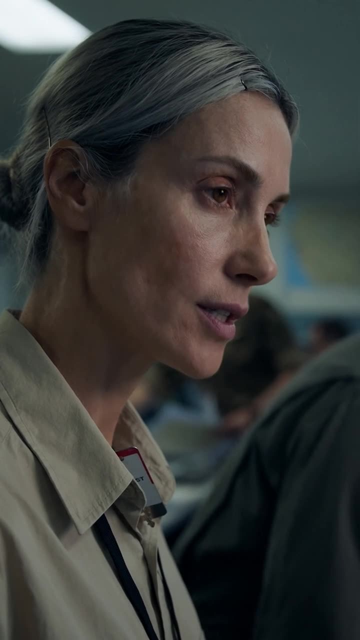 Close-up of Camille maintaining calm composure as she instructs Julien to verify her clearance.