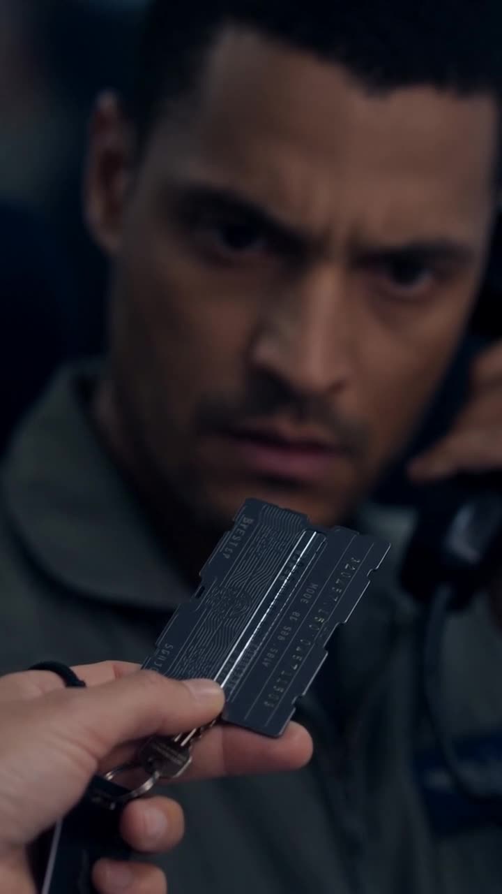 Julien's face freezes in shock as a black titanium key card is held out before him.